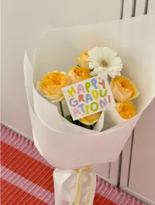 Detailaufnahme einer bunten Abschlusskarte mit farbigen Buchstaben im wunderschönen Blumenstrauss.