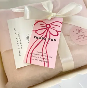 Gift packaging thank you cards set with white ribbon and pink tags for holiday greeting.