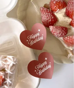 Adhésifs en forme de cœur Bon anniversaire, détail de déco emballage cadeau rouge.