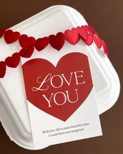 Detailed shot of Valentine's Day greeting card with red heart design and sweet love quote.
