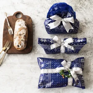 Ensemble ruban de Noël et papier cadeau, design nordique bleu festif avec de jolis rubans blancs.