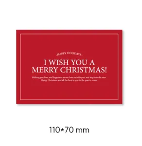 Christmas greeting card detail, red paper message card with elegant white holiday typography.