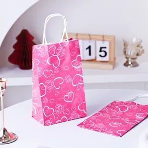 Detailansicht der rosa Papiertragetasche mit romantischem Herz- und Rosenmuster für Geschenke.