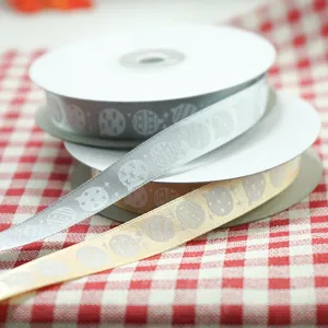 Rouleaux de ruban de Noël avec motifs de boules dorées et argentées, parfaits pour emballage.