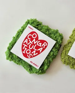 Square greeting card detail shot featuring a red heart design and congratulatory text for birthdays.