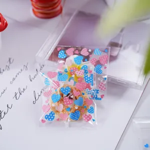 Transparante plastic verpakkingszakjes met kleurrijke hartjes, ideaal voor cadeautjes en snoep.
