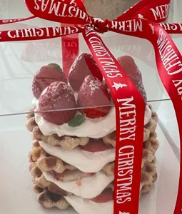 Christmas red ribbon with festive merry christmas text for gift wrapping and holiday decor.