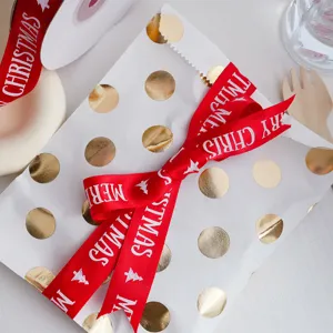 Christmas red ribbon with white Merry Christmas text and tree print for gift wrapping and decoration.