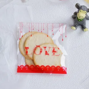 Klares, selbstklebendes Kekstüten-Detail mit rotem LOVE-Druck und festlichen Dekorationen.