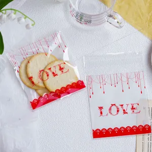 Detailansicht von transparenten Kekstüten mit rotem LOVE-Muster und Spitzen-Design.