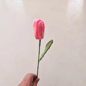 Handmade crochet pink tulip flower detail, single stem knitting yarn floral handicraft.