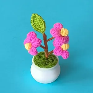 Handmade crochet flower pot detail, cute mini knitted floral decor for desktop or car.
