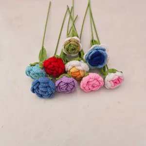 Detail shot of handmade crochet rose flowers with green stems and leaves texture close up