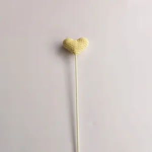 Vista dettagliata fiore a cuore giallo all'uncinetto fatto a mano, accessorio bouquet.