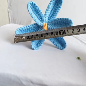 Handcrafted crochet blue flower detail showing size with tape measure, perfect handmade gift.