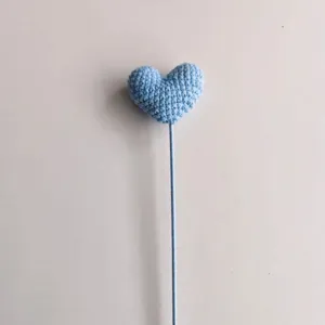 Dettaglio fiore a cuore uncinetto azzurro, accessorio in maglia di lana per regali fai da te.
