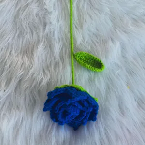 Handmade crochet blue rose detail view, soft yarn flower with green stem, cute gift decor.