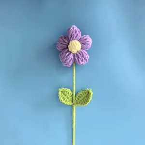 Handcrafted crochet purple puff flower detail shot, showing fine yarn texture and neat stitching clearly.
