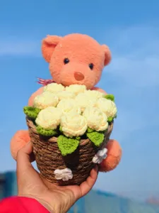 Handmade crochet pink bear holding yellow flower basket bouquet, cute knitted gift ornament.