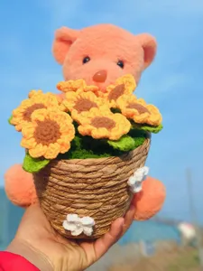 Detailed close-up of handmade crochet sunflower bear pot, delicate wool knit texture.