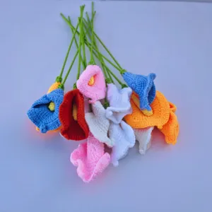 Nahaufnahme des handgemachten Häkel-Calla-Blumenstraußes mit bunten Strickblumen und grünen Stielen.