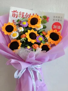 Handmade crochet sunflower bouquet graduation gift wrapped in purple paper with ribbon.