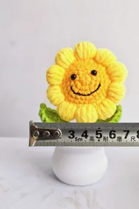 Handcrafted crochet smiley sunflower potted plant, cute knitted flower home decor ornament.
