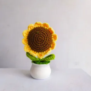 Handmade crochet sunflower potted plant detail view, showing delicate wool knitting texture.
