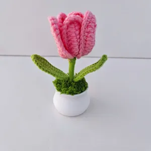 Handmade crochet pink tulip potted plant detail, exquisite knitted floral decor for desktop.
