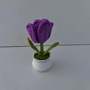 Handmade purple crochet tulip closeup detail, exquisite knitted flower in a white pot for home decor.