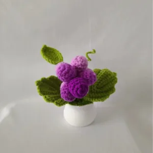Handmade crochet grape potted plant detail, cute purple yarn fruit decor for desktop.