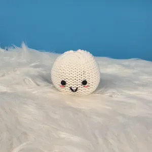 Handgemaakt gehaakt schattig wit broodje speelgoed detail, zachte textuur met glimlach.