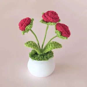 Detailansicht der handgehäkelten roten Rosen im Topf, feine Wollgarn Handwerkskunst Heimdekoration.