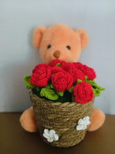 Handmade crochet teddy bear with red rose flower basket, cute knitted gift ornament detail.