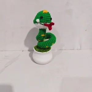 Gedetailleerd uitzicht van gehaakte groene slang in pot, schattige bureau decoratie speelgoed.