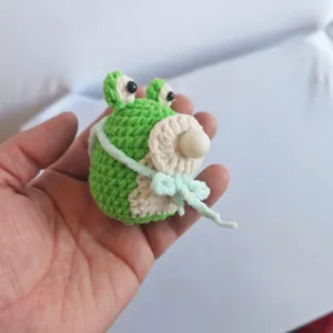 Handgefertigtes Häkel-Frosch Detailbild, niedliches Seifenblasen-Design, weiche Garntextur.