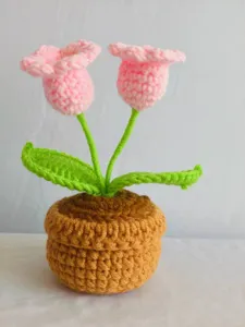Handmade crochet potted plant detail showing neat yarn stitches and pink flower design.