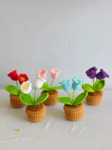 Detail view of handmade crochet potted flowers, showing delicate woven texture and vibrant colors.