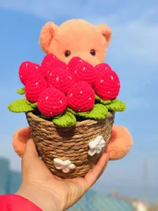 Handmade crochet bear with strawberries potted plant detail, cute woolen flower gift for home decor.