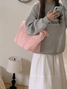 Detailaufnahme einer großen rosa Umhängetasche, weicher Shopper mit Metallbeschlägen.
