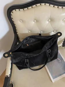 Detailansicht der großen schwarzen Reisetasche mit Reißverschluss und viel Stauraum.