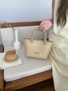 Detailaufnahme der handgeflochtenen Strohtasche mit PU-Lederbesatz in gemütlicher Wohnambiente.