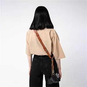 Retro leather camera strap detail view, adjustable shoulder neck strap with metal hardware.