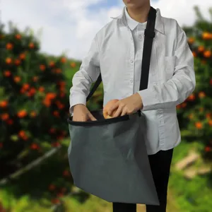 Fruit picking bag detail showing waterproof oxford fabric, durable shoulder strap for orchard harvest.