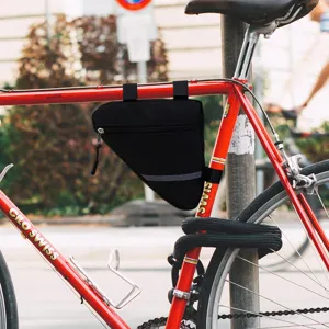 Detail shot of black bicycle triangle frame bag mounted on bike frame with reflective strip.