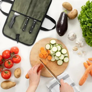 Détail de sac rouleau pour couteaux de chef en toile verte avec multiples rangements.