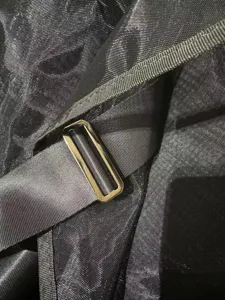 Close-up detail of the adjustable metal buckle and breathable mesh fabric on horse fly sheet.