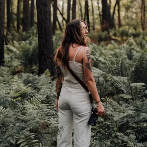 Outdoor photography adjustable camera strap detail shot in natural forest environment setting.