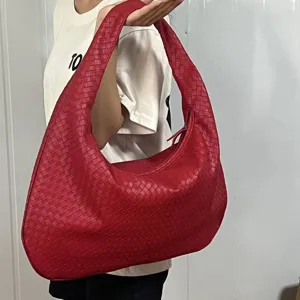 Detailed shot of red woven leather hobo shoulder bag showing exquisite handcrafted texture.
