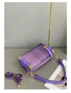 Violette Handtasche im Kasten-Design mit Metall-Ecken und Schulterriemen für Damen.